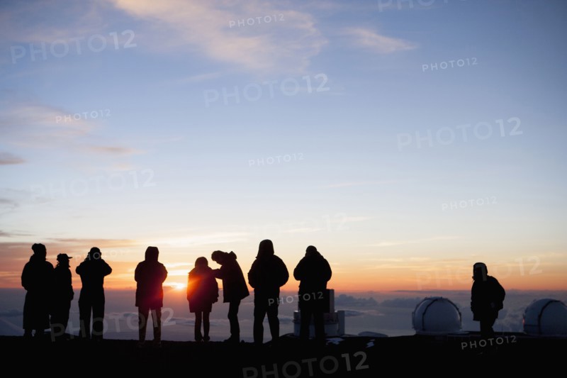 Silhouette of tourists admiring view from mountaintop