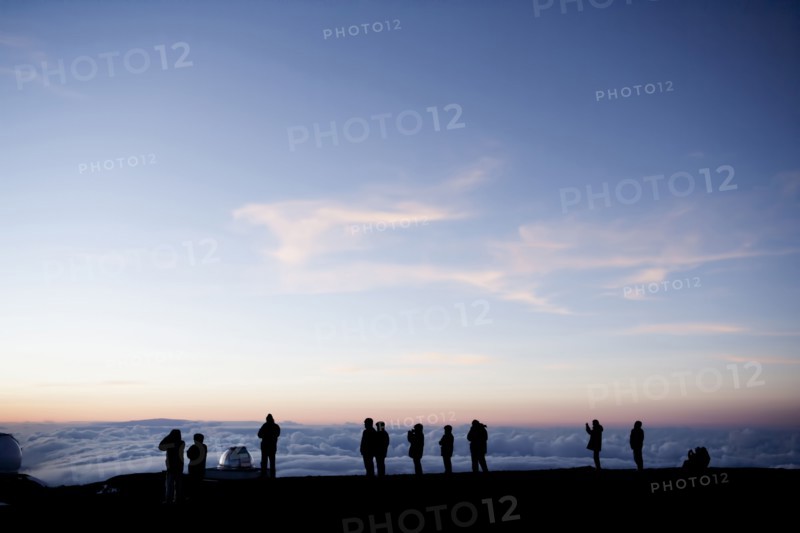 Silhouette of tourists admiring view from mountaintop