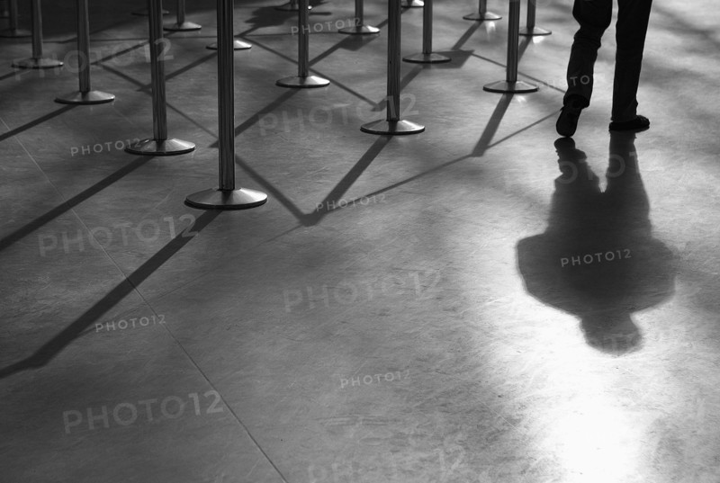 Shadow of man and roped-off barriers