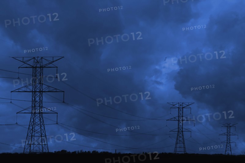 Silhouette of power lines under dark cloudy sky