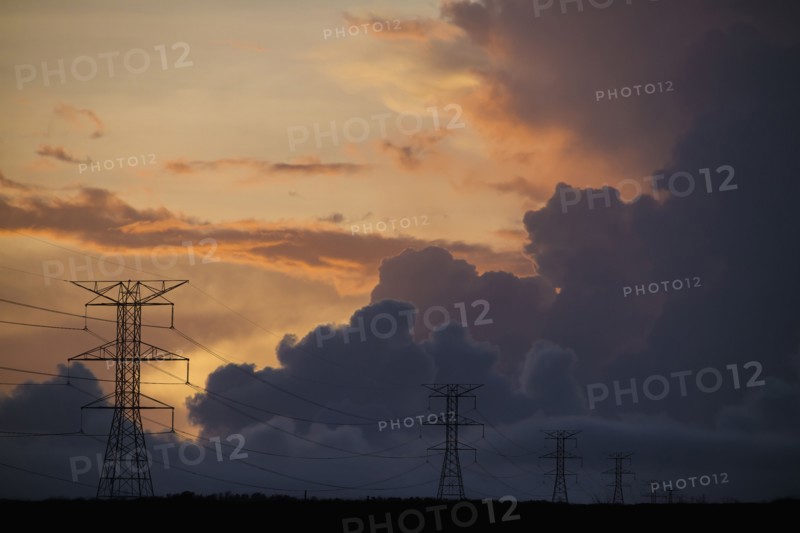 Silhouette of power lines under cloudy sky