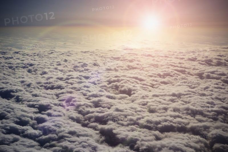 Sun shining in sky above clouds