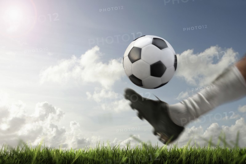 Blurred view of foot kicking soccer ball