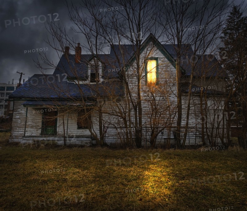 Glowing window casting light in backyard