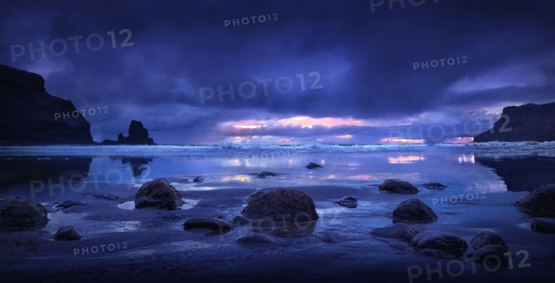 Rocks on beach under storm clouds