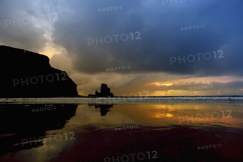 Storm clouds over waves on beach