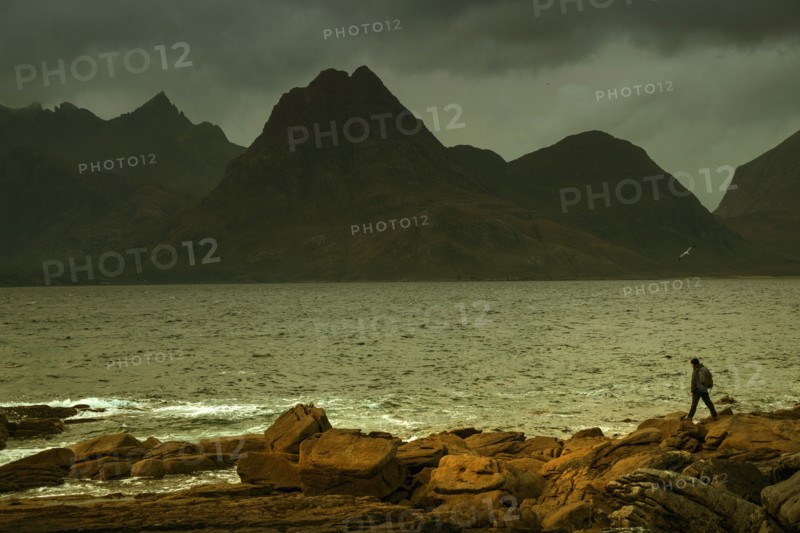 Man walking on rocky beach