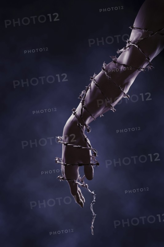 Arm and hand wrapped in barbed wire