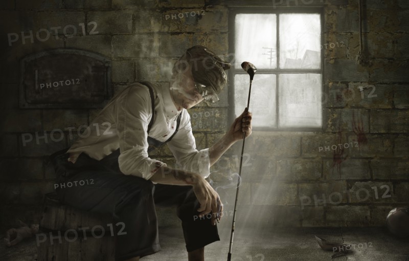 Man smoking cigarette with golf club