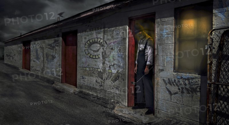 Man standing in dilapidated building doorway