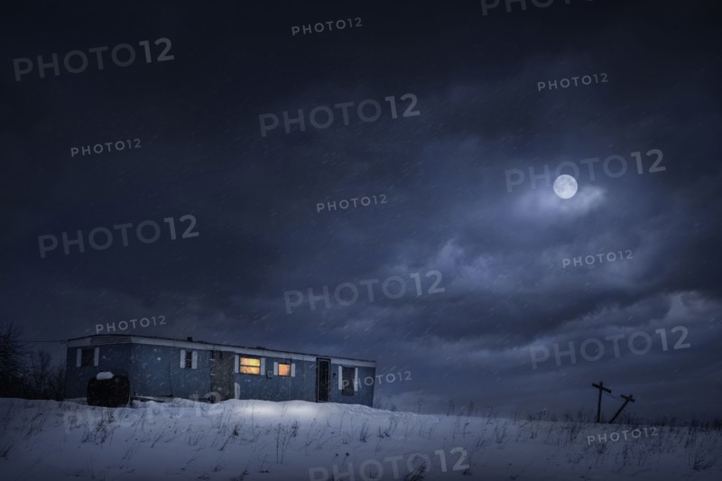 Moon over trailer house in snowy yard