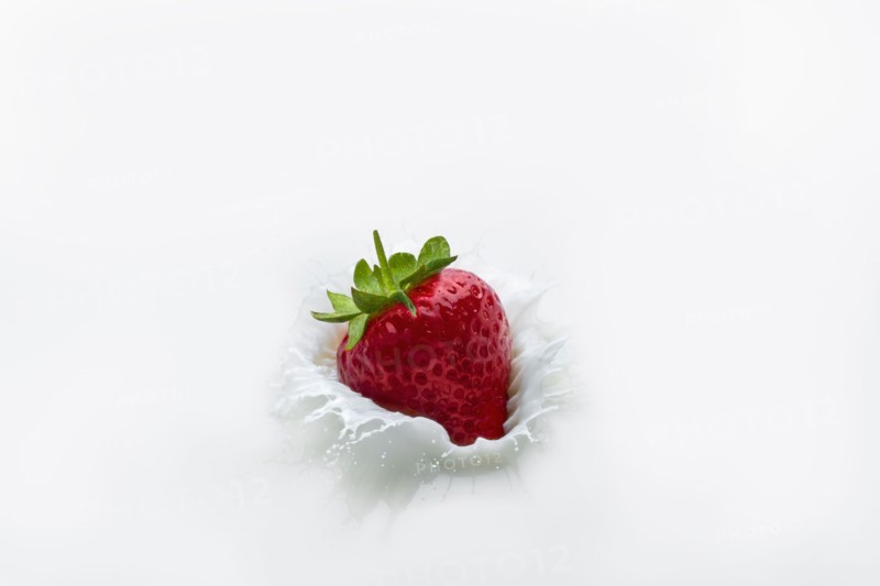 Strawberry splashing into milk