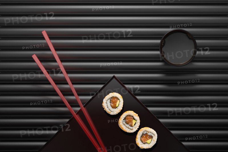 Chopsticks and sushi on square plate with dipping sauce