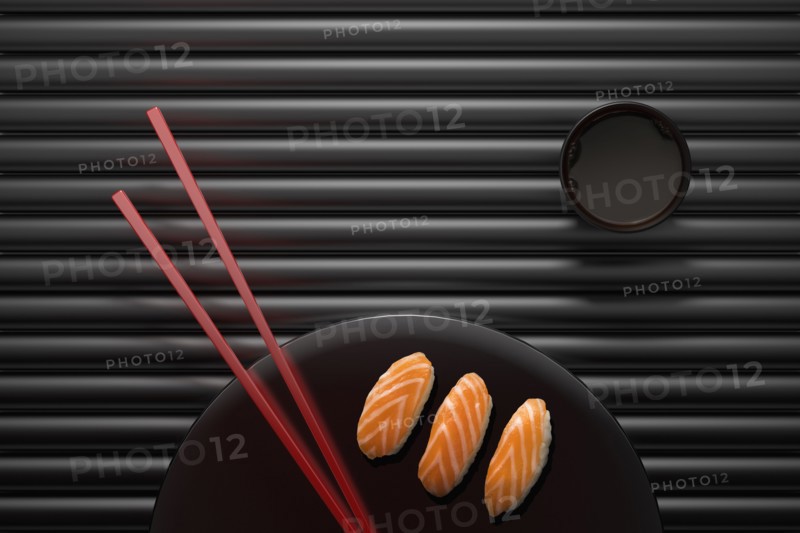 Chopsticks and sushi on round plate with dipping sauce