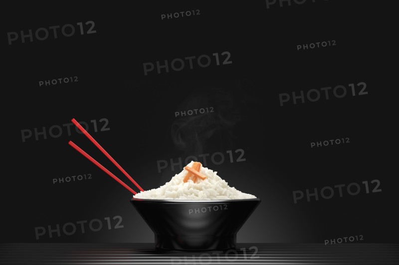 Chopsticks in bowl of steaming white rice