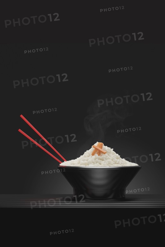 Chopsticks in bowl of steaming white rice