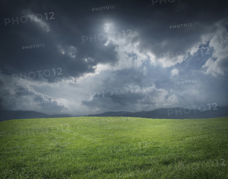 Storm clouds over green field
