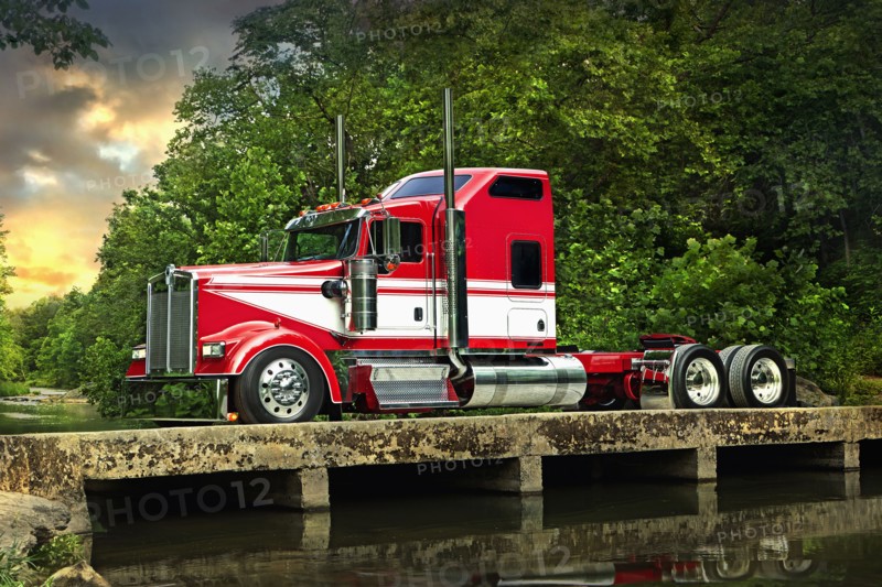 Semi-truck driving on bridge over river