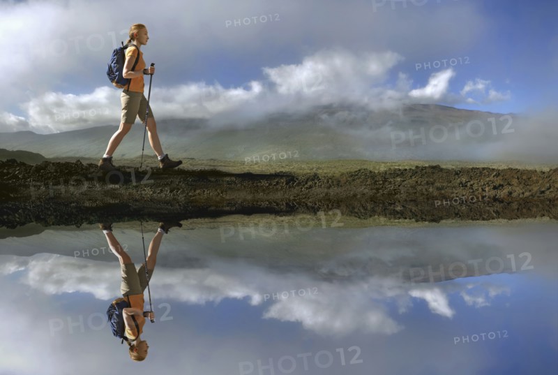 Reflection of Caucasian girl hiking at river