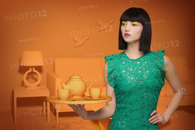 Caucasian woman in orange old-fashioned livingroom holding tea service