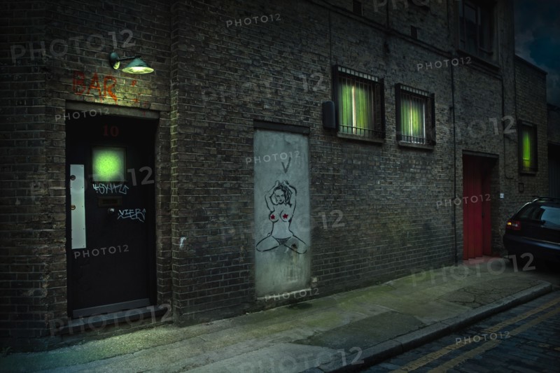 Graffiti on alley doors in city at night