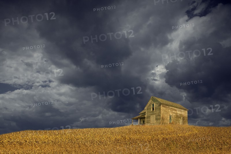 Storm clouds over remote wooden farmhouse