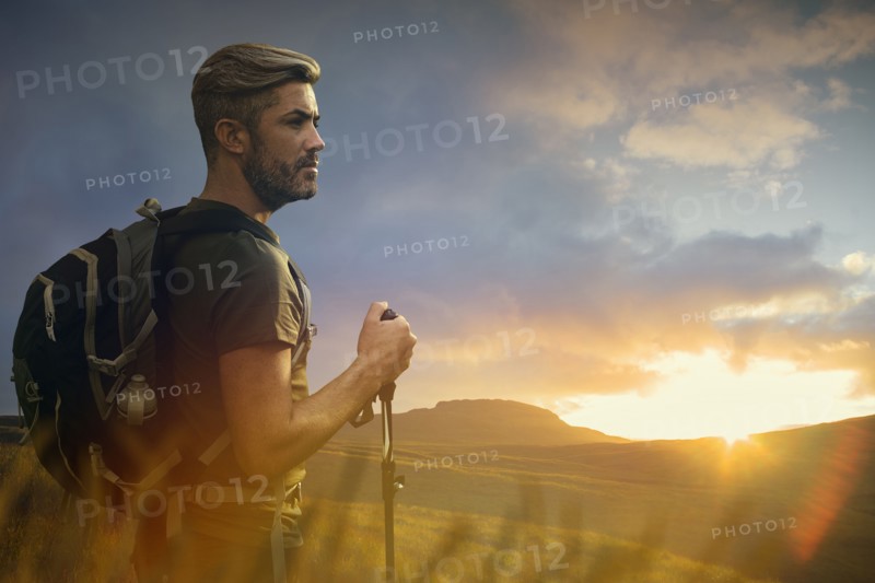 Caucasian hiker admiring landscape at sunset
