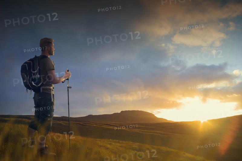 Caucasian hiker admiring landscape at sunset