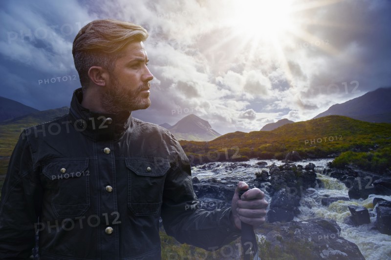 Caucasian hiker holding walking stick near river