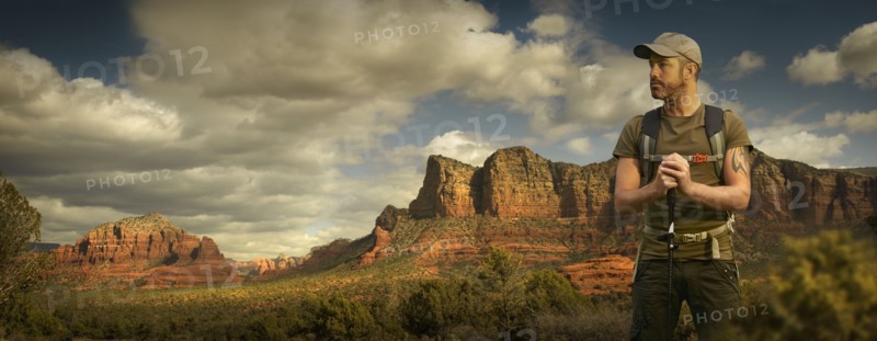 Caucasian hiker holding walking stick in desert landscape