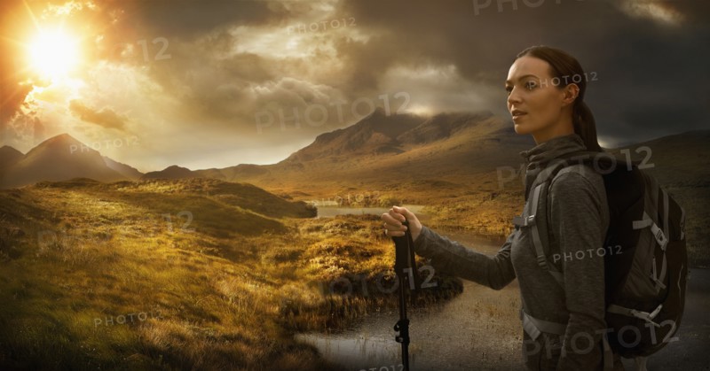 Caucasian woman hiking near mountain river at sunset