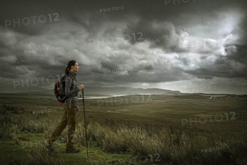 Caucasian woman hiking in green landscape