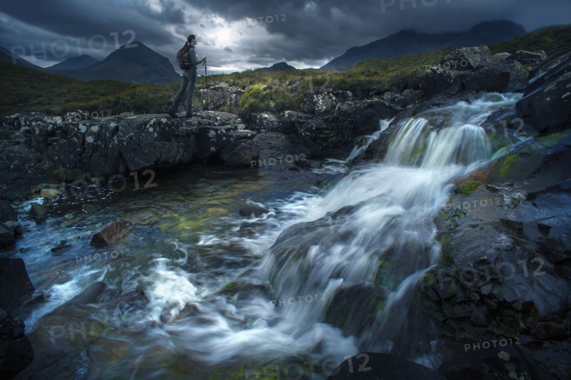 Caucasian woman hiking near river flowing over rocks
