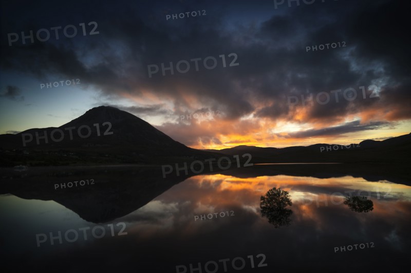 Reflection of sunset and mountain in water