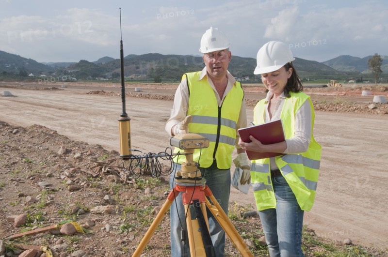 Construction workers examining equipment in field