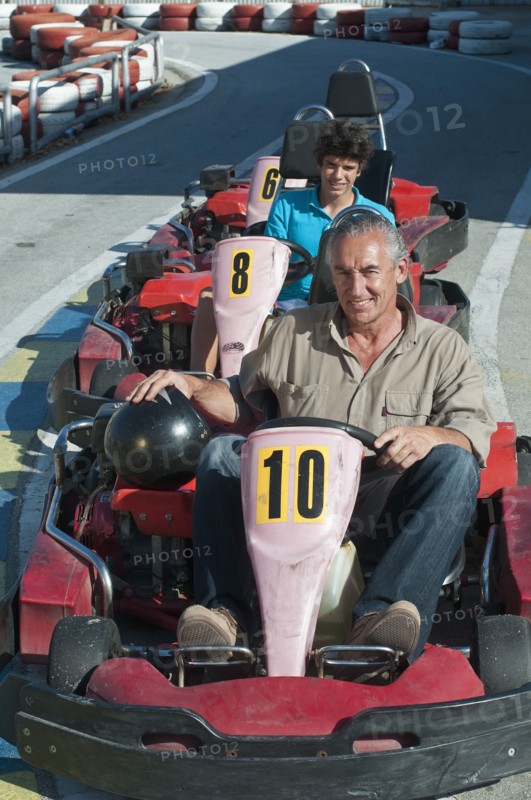 Hispanic grandfather and grandson on go-cart track