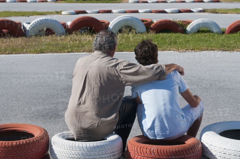 Hispanic grandfather and grandson on go-cart track