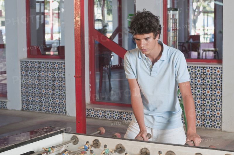 Hispanic teenager playing foosball