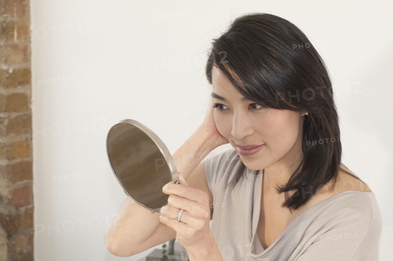 Korean woman looking in mirror