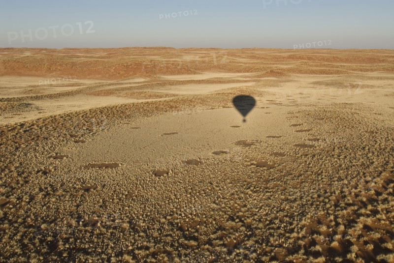 Shadow of hot air balloon over desert