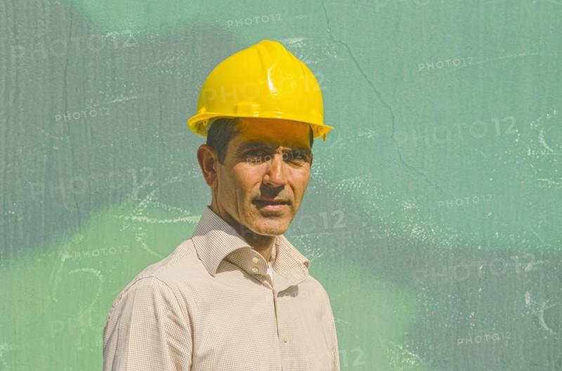 Hispanic worker wearing hard hat outdoors