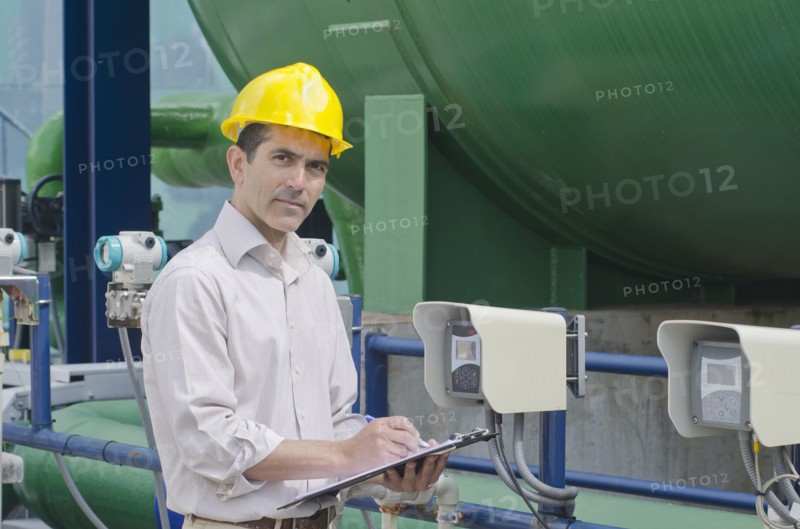 Hispanic worker checking machinery