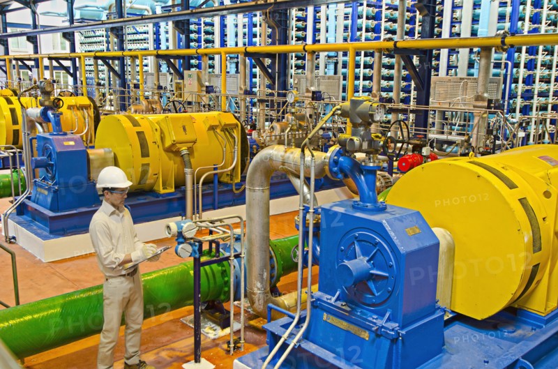 Hispanic worker checking machinery