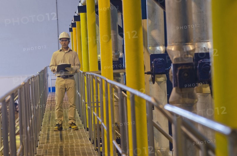 Hispanic worker checking machinery
