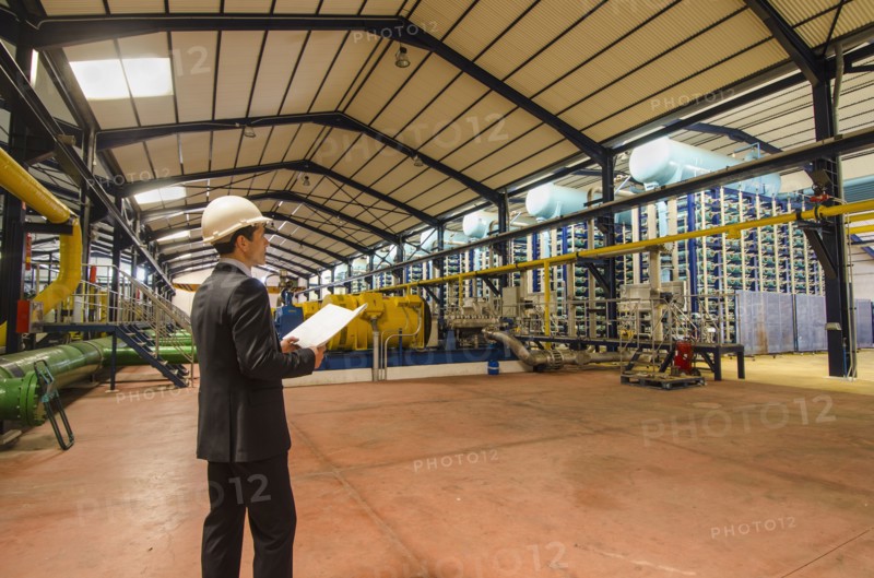 Hispanic businessman checking machinery
