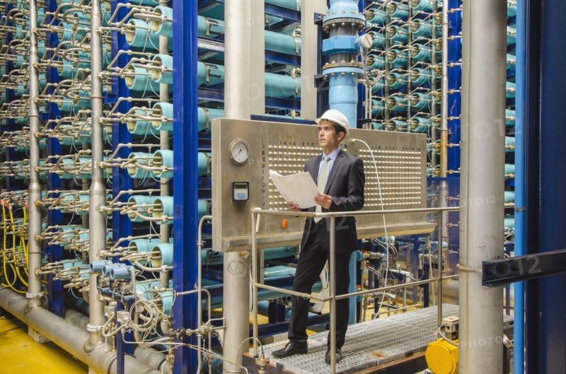 Hispanic businessman checking machinery