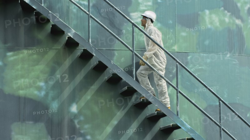 Hispanic worker climbing water tower