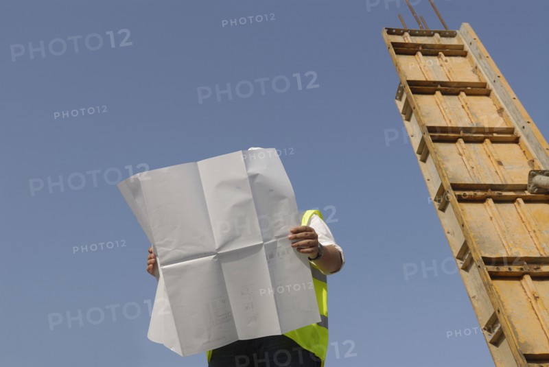 Engineer looking at plan on construction site low angle view