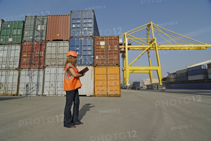 Female worker with clipboard in cargo container terminal