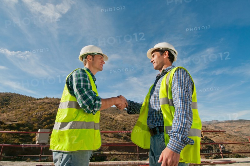 Two construction engineers shaking hands
